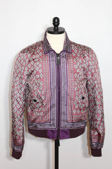 A pink and purple patterned bomber jacket displayed on a black dress form mannequin against a white background.