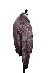 A patterned long-sleeve button-up shirt displayed on a mannequin torso against a plain light background. The shirt features a geometric diamond pattern in burgundy, white, and gray, with striped detailing on the collar, cuffs, and hem.