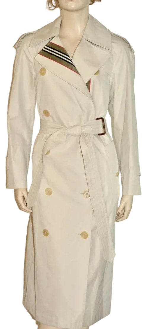 A cream-colored double-breasted trench coat with a waist belt, shown on a mannequin against a plain white background.