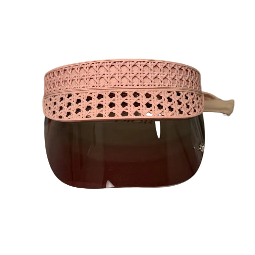A pink woven straw hat with a brown leather band and matching brown sunglasses, displayed on a white block.