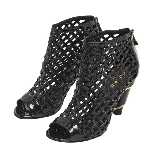 Black open-toe shoes with cut-out design on a white background