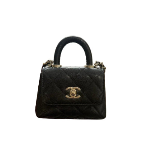 Black quilted handbag with gold Chanel logo on a white background