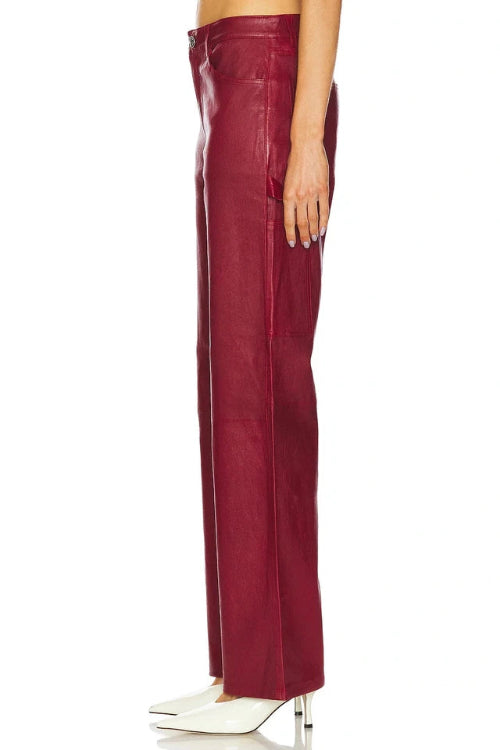 Burgundy leather pants worn by a person on a white background