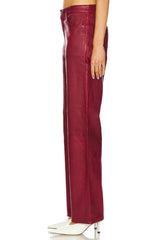 Burgundy leather pants worn by a person on a white background