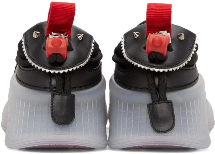 Close-up rear view of a pair of black and white sneakers with red pull tabs and silver studs, shown on a white background.