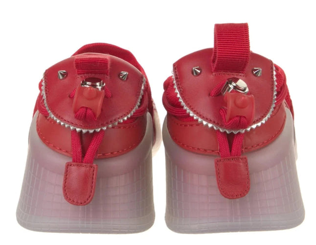 A pair of red leather platform sneakers with translucent pinkish-red platform soles and silver-tone hardware, shown from the back against a white background.