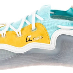 A close-up of a sneaker featuring a bright yellow toe box, a light blue suede upper, white laces, and a translucent gray and white sole.