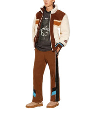 Person wearing a brown and white jacket with matching pants on a white background