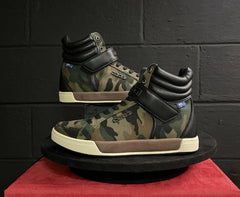 Camouflage-patterned high-top sneakers on a red platform with a black sole.