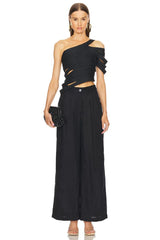 Woman wearing a black one-shoulder top and wide-leg pants on a white background