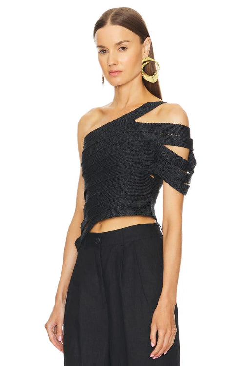 Woman wearing a black one-shoulder top with cut-out design on a white background