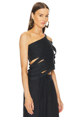 Woman wearing a black one-shoulder dress with cut-out details on a white background