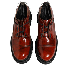 Pair of brown leather shoes with black soles on a white background