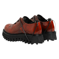 Brown leather shoes with black soles on a white background