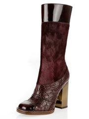 A mid-calf boot featuring a mix of textures, including a dark burgundy faux-hair texture, a glossy dark brown patent leather collar, and a metallic gold block heel with a matching dark brown textured toe cap, shown on a white background.