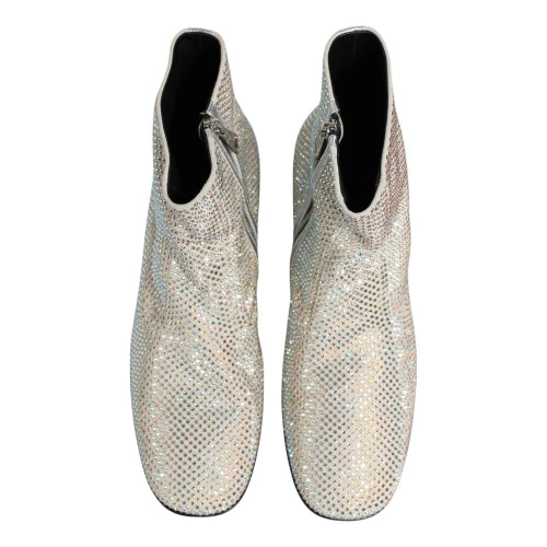 A pair of silver snakeskin ankle boots covered in sparkling rhinestones, shown from a top-down view on a white background.