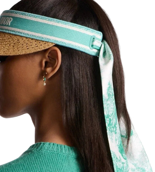 Woman wearing a green top with a matching headband against a blurred background