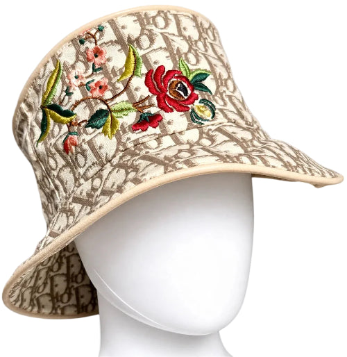 Beige bucket hat with floral embroidery on a white mannequin head