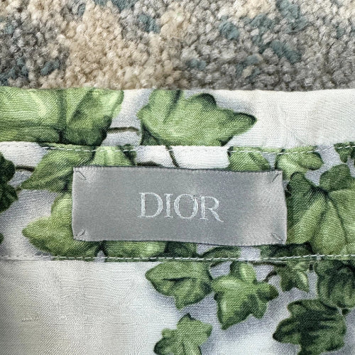 Dior fabric with green leaf pattern and visible label on a textured surface