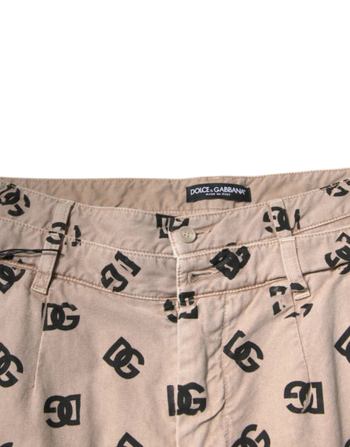 Beige pants with black logo pattern and Dolce & Gabbana label on a white background