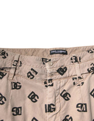 Beige pants with black logo pattern and Dolce & Gabbana label on a white background