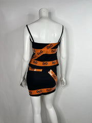 Black dress with orange branding on a mannequin against a gray background