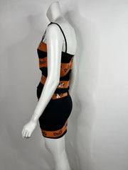 Black and orange striped dress on a mannequin against a gray background