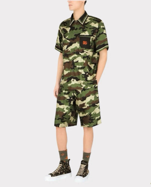 Person wearing a camouflage outfit with a brand logo on a white background