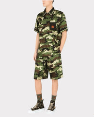 Person wearing a camouflage outfit with a brand logo on a white background