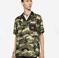 Person wearing a camouflage shirt with a brand logo on a white background