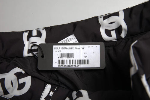 Black pants with white logo pattern and a tag on a light gray background