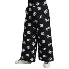 Black pants with white logo pattern worn by a person on a white background