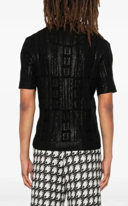 Person wearing a black textured sweater with a white background