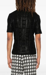 Person wearing a black textured sweater with a white background