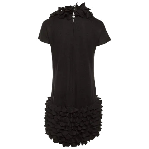 Black dress with ruffled details on a plain background