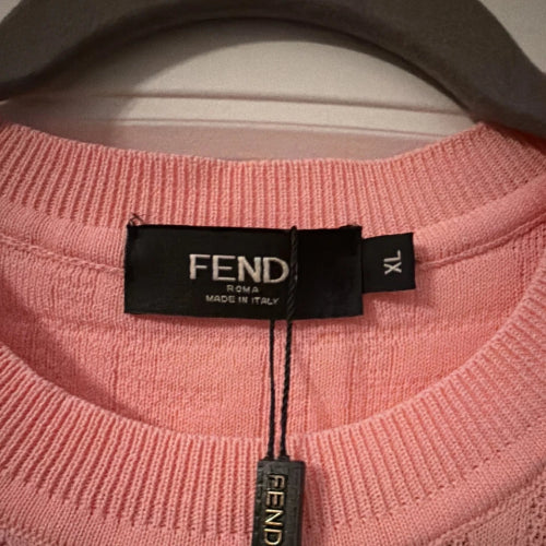 Close-up of a pink sweater with a Fendi label on a hanger.