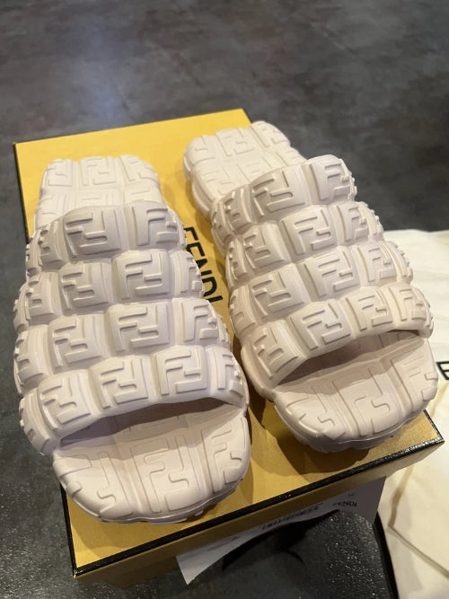 Pair of white gloves with black patterns on a cardboard surface
