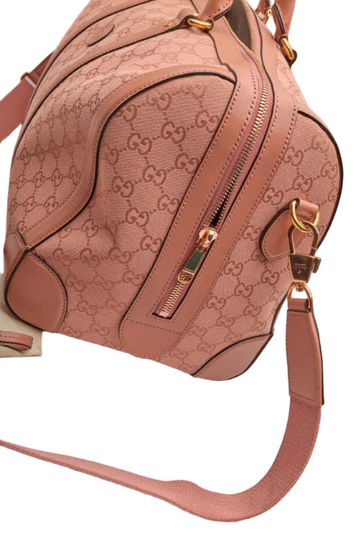 Pink handbag with Gucci logo pattern on a light background