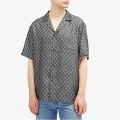 Person wearing a patterned short-sleeve shirt on a white background