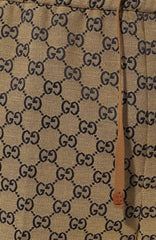 Close-up of a beige fabric with black Gucci logo pattern