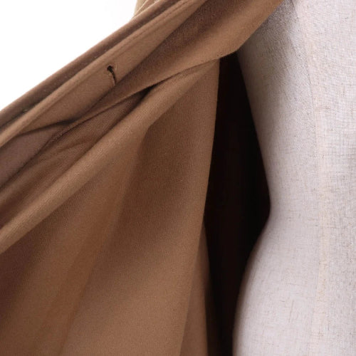 Close-up of brown fabric with a visible seam on a white background