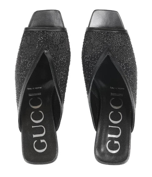 Black studded high-heeled shoes with Gucci logo on a white background