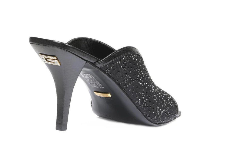 Black high-heeled shoe with glittery texture on a white background