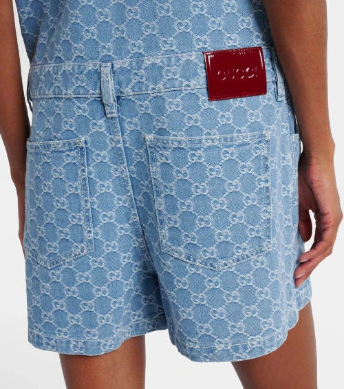 Blue patterned shorts with a Gucci logo patch on a white background