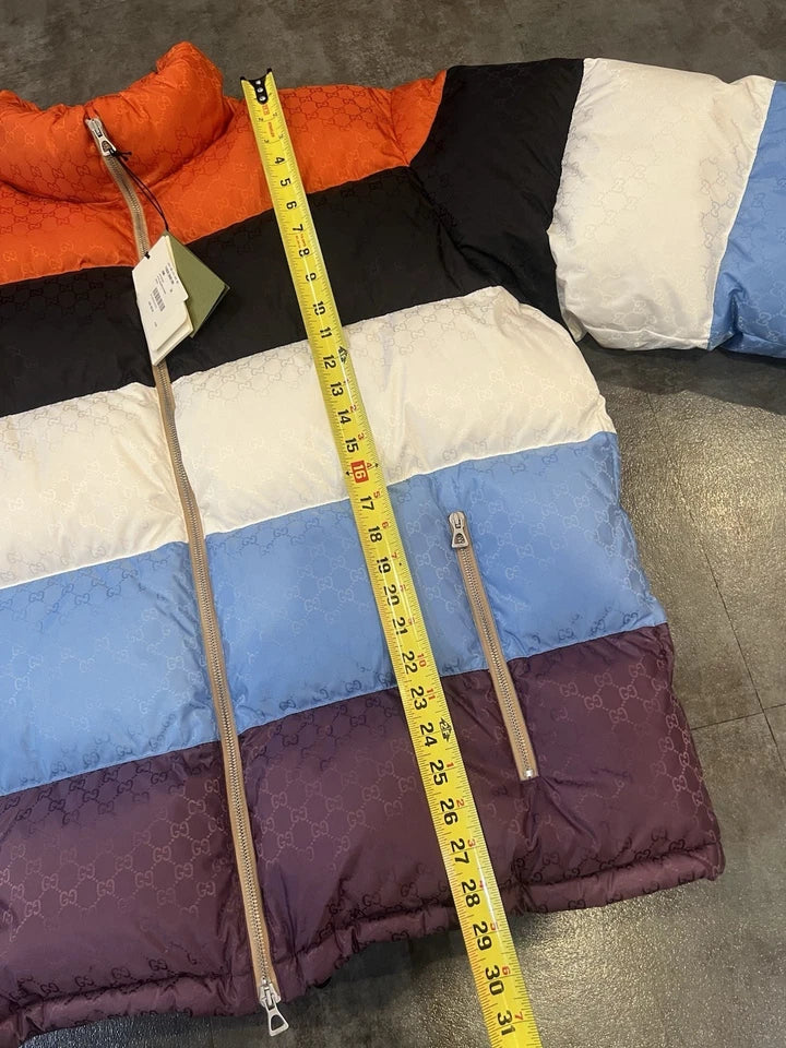 Multicolored puffer jacket with a measuring tape on a gray surface