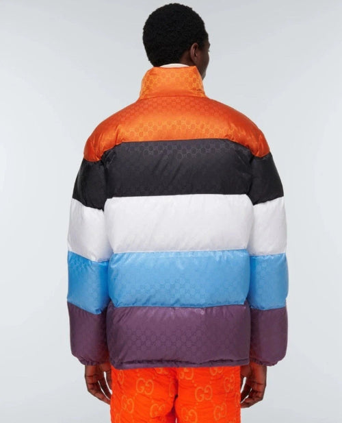 Person wearing a colorful quilted jacket with a white background