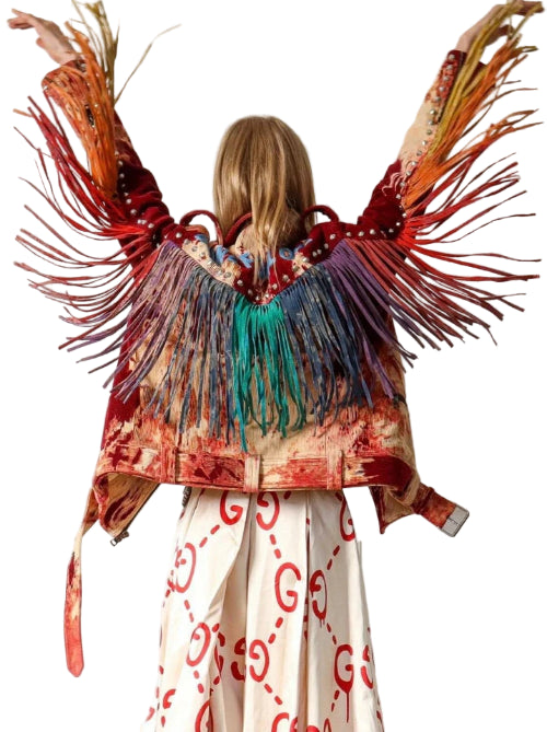 Person wearing a colorful fringed jacket with a white wall background