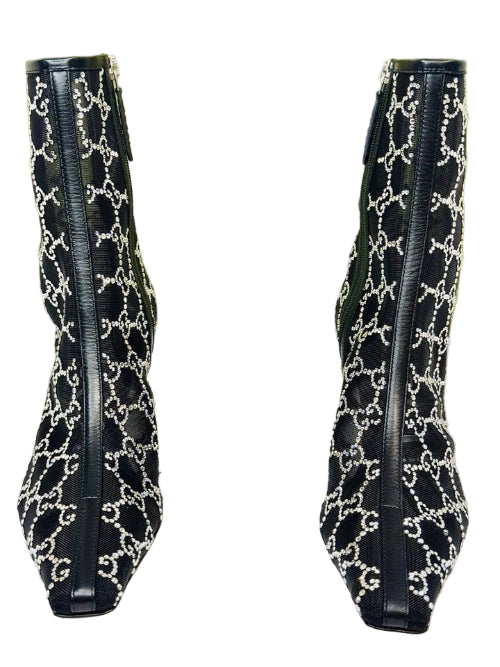 Black high-heeled boots with white pattern on a Gucci branded background