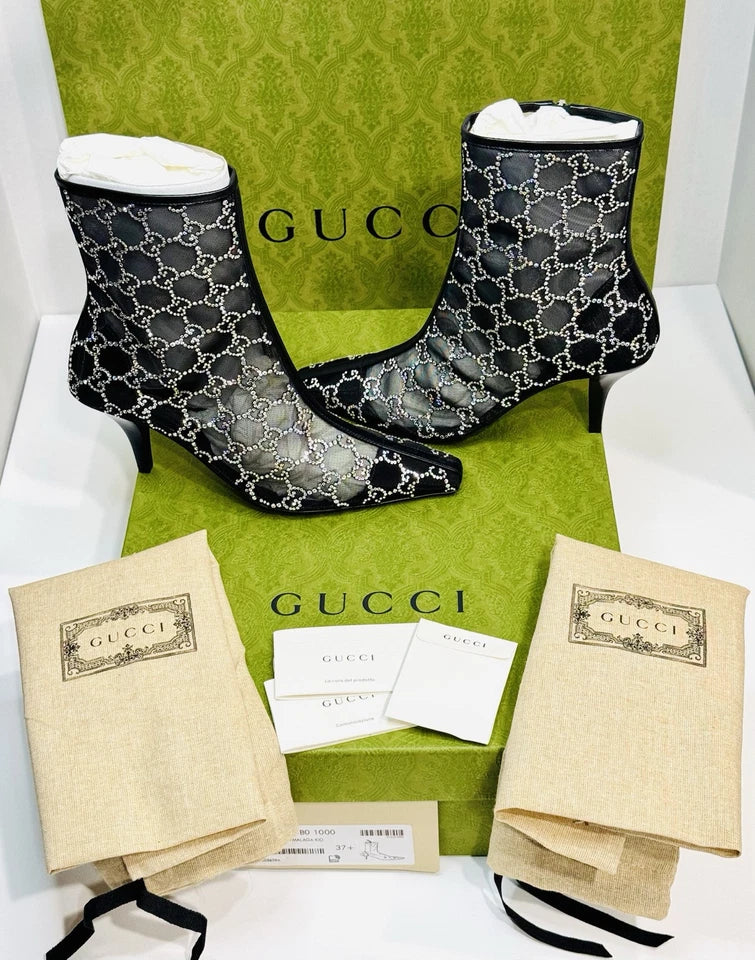 Gucci black patterned ankle boots with branded box and packaging on a white background