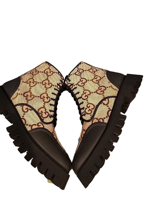 Black wedge sandals with patterned insole on a green surface